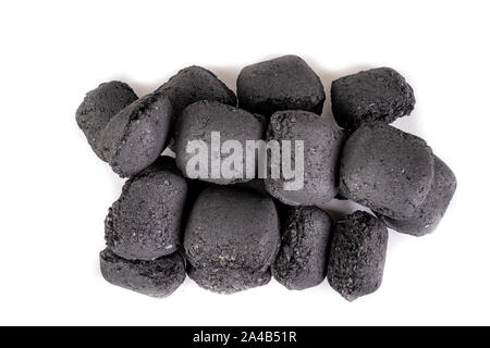 Briketts zum Grillen von Fleisch verwendet werden. Gedrückt Kohle für das Rauchen in den Grill. Hellen Hintergrund. Stockfoto