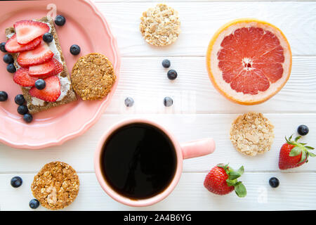 Leckere vegetarische Frühstück, leckeres Sandwich mit frischen Erdbeeren und Käse, gesunde oat Cookies auf weiße Holztisch Hintergrund. Stockfoto