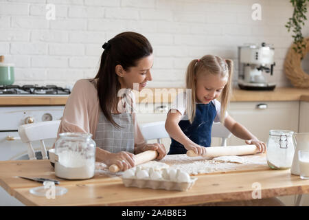 Glückliche Mutter und Tochter heraus rollen Teig zusammen Stockfoto