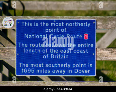 Ein blaues Schild markiert den nördlichsten Punkt des britischen National Cycle Route 1, in Skagen auf der Insel Unst in Shetland, Schottland, Großbritannien. Stockfoto