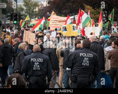 Viele Polizisten und Polizei Autos am Protest gegen die türkische Politik und Offensive im Norden Syrien/Kurdistan, kurdische und YPG Flaggen im Hintergrund Stockfoto