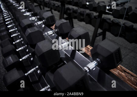 Schließen viele Metall Kurzhanteln auf Rack im Sport Fitness center Stockfoto