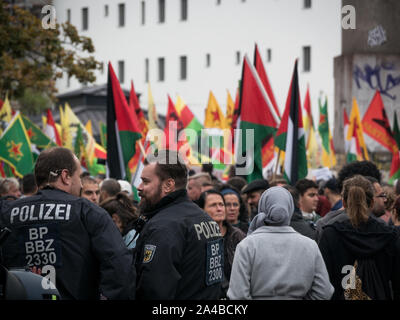 Viele Polizisten und Polizei Autos am Protest gegen die türkische Politik und Offensive im Norden Syrien/Kurdistan, kurdische und YPG Flaggen im Hintergrund Stockfoto