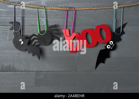 Halloween Fledermäuse, Spinnen und roten 'Buh' Photo Booth Requisiten an ein Garn mit großen farbenfrohen Büroklammern. Kopieren Sie Speicherplatz auf der Unterseite. Stockfoto
