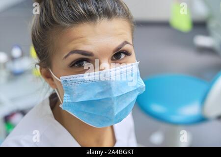 Closeup Portrait von lächelnd weibliche Zahnarzt Arzt in schützende medizinische Maske am Arbeitsplatz zahnmedizinische Klinik Büro, positiven Gesicht Stockfoto
