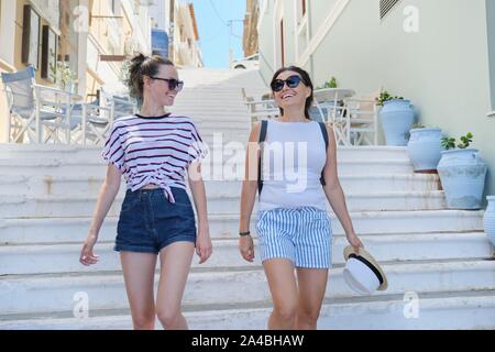 Mutter und Tochter Teenager gehen und zusammen gesprochen, Sommer City Resort Hintergrund weiß Treppe Stockfoto