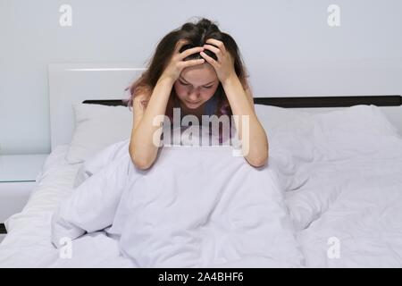 Traurige Teenager Mädchen zu Hause im Bett sitzen. Stockfoto