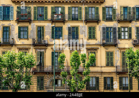 Gelbes Haus mit grünen Fensterläden und schmiedeeisernen Balkonen entlang Corso Cairoli, Turin, Italien Stockfoto