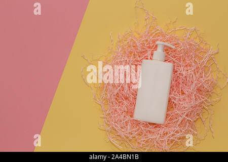 SPA Kosmetik weiße Wanne, Branding mock up, Ansicht von oben auf rosa und gelben bunten Hintergrund auf Papier Lametta. Stockfoto