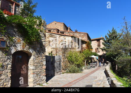 Charmante Kopfsteinpflasterstraße nur Fußgängerzone in der mittelalterlichen europäischen Stadt. Häuser aus Stein, bestreut mit Fensterläden aus Holz, Tore und exotischer Vegetation. sonnigen Tag. Stockfoto