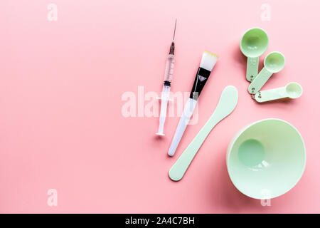 Tools und Injektor für zu Hause oder im Salon Gesichtspflege auf rosa Hintergrund, Ansicht von oben, flach. Serum, Maske. Mockup. Hautpflege Stockfoto