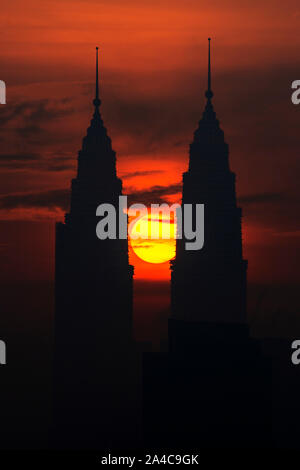 Kuala Lumpur, Malaysia. 14 Okt, 2019. Die Sonne steigt aus der Richtung zwischen den Petronas Twin Towers in Kuala Lumpur, Malaysia, Okt. 14, 2019. Credit: Chong Voon Chung/Xinhua/Alamy leben Nachrichten Stockfoto