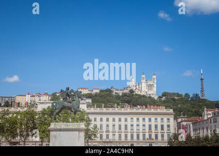 Roi Louis XIV Statue auf Anzeige auf dem Place Bellecour Square, in der Innenstadt von Lyon, Frankreich, mit der Basilika Notre Dame De Fourviere Kirche in backgrou Stockfoto