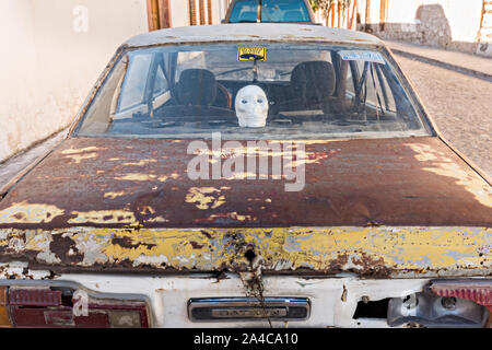 Ein altes Auto mit einem totenkopf dekoration in der Geisterstadt Mineral de Pozos, Guanajuato, Mexiko geparkt. Die Stadt, einst eine große Silver mining Zentrum aufgegeben wurde und Links zu ruinieren, hat aber langsam Comeback zum Leben als Bohemien arts community. Stockfoto