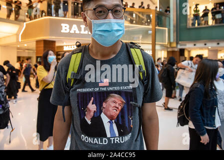 Hongkong, China. 13 Okt, 2019. Eine Demonstrantin Tragen eines US-Präsidenten J Donald Trump t-shirt Teil nimmt während der Demonstration. Hongkongs Regierung ein Anti-mask Gesetz, das Menschen verbietet das Tragen von Masken in öffentlichen Versammlungen die Empörung in der Bevölkerung ausgelöst. Hong Kong hat für über vier Monate von massiven Demonstrationen gegen die Regierung erschüttert wurde. Credit: SOPA Images Limited/Alamy leben Nachrichten Stockfoto