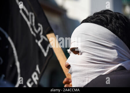 Srinagar, Indien. 11 Okt, 2019. Kaschmir ein Maskierter Demonstrant hält eine Flagge während der Demonstration nach dem Freitagsgebet hunderte von Menschen an einer Demonstration in der Soura Nachbarschaft nahm. Spannungen eskalieren, da die indische Regierung eine teilweise Autonomie der Region vor drei Wochen entfernt. Informationen hat auch knapp, wie Internet und mobile Netze wurden gesperrt. Credit: SOPA Images Limited/Alamy leben Nachrichten Stockfoto