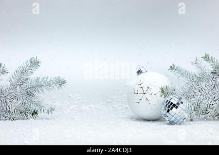Weihnachtsbaum, Zweige und dekorativen Kugeln aus Glas auf flauschigen weißen Schnee Hintergrund Stockfoto