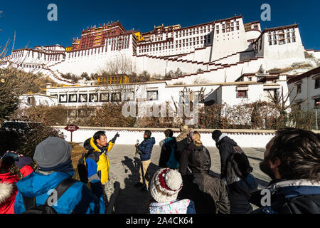 Lhasa, China - 13. Dezember 2018: Internationale Touristen zu Ihren Reiseleiter zu hören der Potala Palast im Herzen der Altstadt von Lhasa in Tibet pro Stockfoto