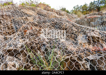 Sicherheit Metall net deckt den felsigen Klippen von Steinschlag in Italien Stockfoto