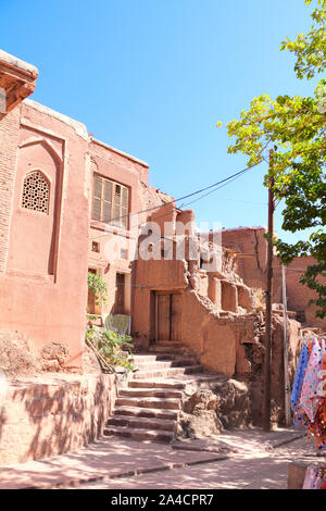 Die Straße mit roten Adobe Häuser in Berg Dorf Abyaneh, der ältesten Iranischen traditionellen Dorf im zentralen Teil des Iran. UNESCO-er Stockfoto