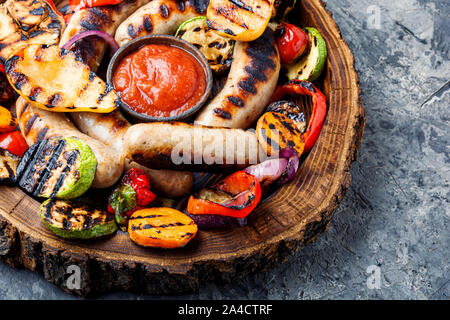 Gegrillte Würstchen und Gemüse mit Sauce Ketchup auf Holz fach Bbq Essen Stockfoto