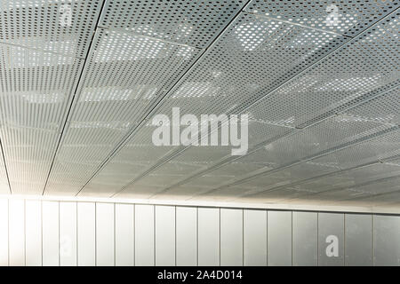 Blick diagonal von metall gitter und runde Löcher in Metallen Deckenfläche, perforierte Panels Stockfoto