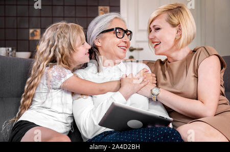 Drei Generationen von Frauen genießen Freizeit zusammen verbringen in einem Wohnzimmer Stockfoto