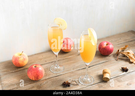 Apple Mimosa Cocktail auf Holztisch, kopieren. Saisonale herbstliche Getränke für Feiertage - Champagner mimosa Cocktail mit Äpfeln. Stockfoto