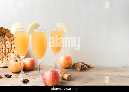 Apple Mimosa Cocktail auf Holztisch, kopieren. Saisonale herbstliche Getränke für Thanksgiving Feiertage - Champagner mimosa Cocktail mit Äpfeln. Stockfoto