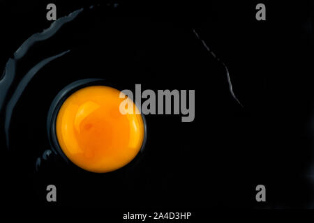 Rohe Eier ohne Schale und Eigelb auf dunklem Hintergrund Stockfoto