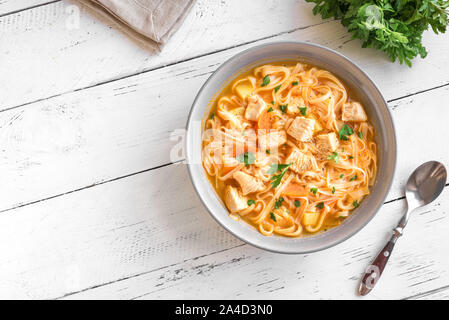 Huhn Nudelsuppe mit Gemüse und Petersilie auf weißen, Ansicht von oben, kopieren. Hausgemachte Huhn oder Truthahn Suppe. Stockfoto