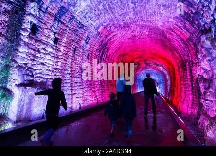 Brockville, Kanada. 13 Okt, 2019. Menschen gehen durch die brockville Eisenbahntunnel in Brockville, Ontario, Kanada, Okt. 13, 2019. Neben einem modernen LED Light System farbig, dieser kanadischen ersten Eisenbahntunnel wurde in der Öffentlichkeit als eine Spur seit 2017 geöffnet. Credit: Zou Zheng/Xinhua/Alamy leben Nachrichten Stockfoto