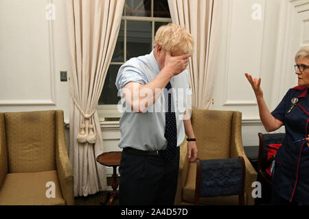 Premierminister Boris Johnson reagiert in Downing Street, wo er eine Grippe impfen hatte, vor der Teilnahme an der Eröffnung des Parlaments. Stockfoto