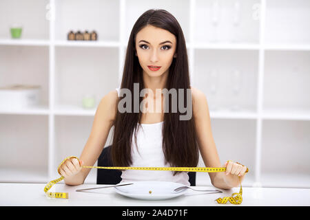 Essstörung. Mädchen ist eine Platte und versuchen, eine erbse auf der Gabel zu setzen Stockfoto