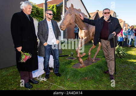 Zamrsk, Tschechische Republik. 12 Okt, 2019. (L - R) Bildhauer Petr Novak, Jockey Zdenek Matysik und Inhaber der Peruan Aufenthalt vor der Bronzestatue von peruan Race Horse in Zamrsk, Tschechische Republik, 12. Oktober 2019. Peruan gewann den Grand Pardubitzer Steeplechase dreimal und seine Statue außerhalb der Pferderennen in Zamrsk vorgestellt wurde am Vorabend der Hindernislauf. Peruan wurde auf einem Bauernhof in Zamrsk ausgebildet, er lebte und starb dort 2017. Quelle: David Tanecek/CTK Photo/Alamy leben Nachrichten Stockfoto