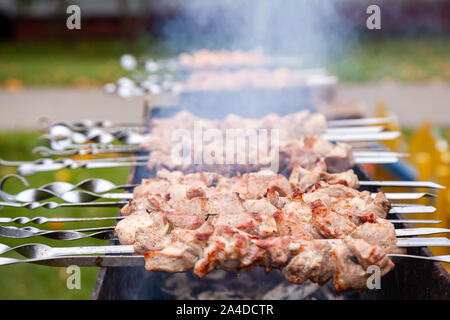 Stücke von Fleisch sind Freund auf Feuer auf Spieße auf Grill. Nach oben Schließen Stockfoto