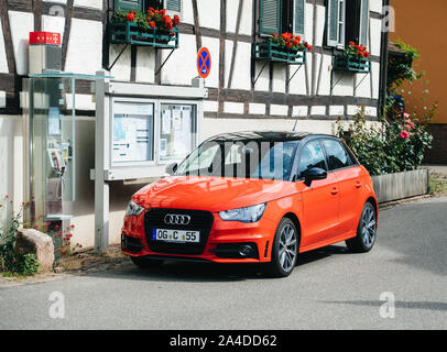 Frankfurt, Deutschland - May 23, 2017: Roter Audi A1 Mini Auto auf dem deutschen Straße in der Nähe einer Werbetafel und Deutsche Telekom Telefonzelle geparkt Stockfoto