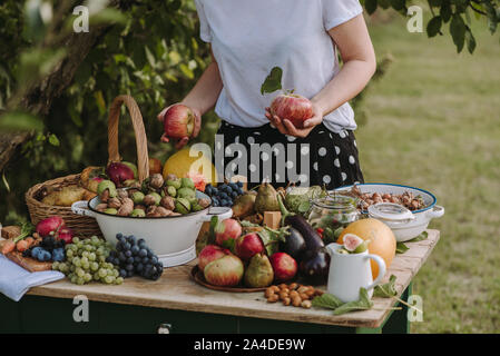 Frau um einen Tisch mit Obst und Gemüse die Äpfel, Serbien Stockfoto