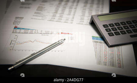 Financial Business berichtet über einen Schreibtisch mit einem Stift und Taschenrechner Stockfoto