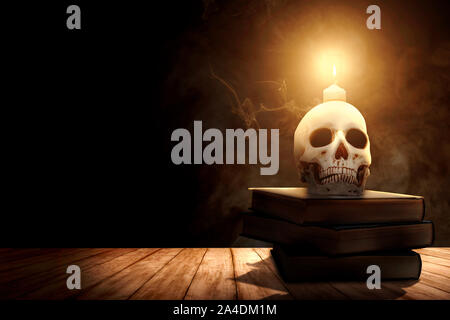 Stapel des Buches mit einem menschlichen Schädel und Kerzenschein auf einem Holztisch auf dunklem Hintergrund Stockfoto