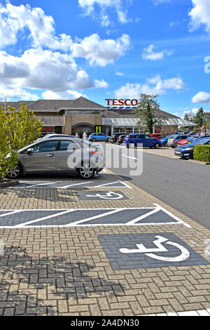 Behinderte Parkplatz Symbole auf Block ebnet in Tesco Supermarkt Kunden Parkplatz im Stadtzentrum von Ely, Cambridgeshire East Anglia England UK lackiert Stockfoto