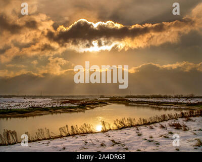 Winter Sonnenaufgang über dem Fluss mit Schnee am Flussufer Stockfoto