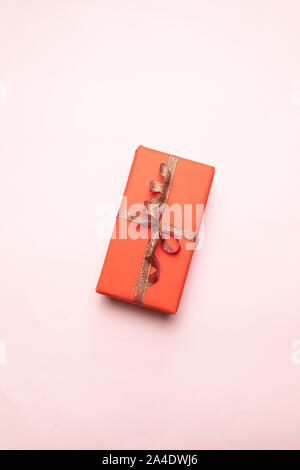 Kreative Zusammensetzung der Geschenkkarton mit gold Dekoration Bug auf rosa Hintergrund. Minimalen Begriff für Geburtstag, Muttertag oder Hochzeit. Stockfoto