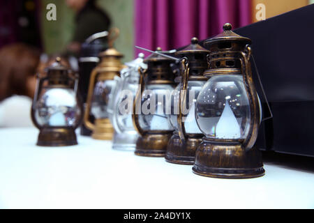 Vintage kleine alte Petroleumlampen auf einer hölzernen Hintergrund. Alte kleine Öllampen in Vintage, retro Ton. Stockfoto