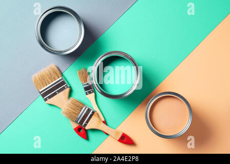 Metall Lackdosen und Pinsel über mehrfarbige Hintergrund. Ansicht von oben. Kopieren Sie Platz. Trendy grün Konzept. Stockfoto