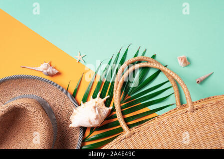 Sommer reisen Konzept mit Frauen Stroh Beutel, Hut, Palmblättern, Muscheln am trendigen gelben und grünen Hintergrund. Ansicht von oben. Kopieren Sie Platz. Nachhaltige lifestyl Stockfoto