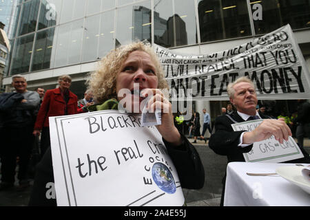 Demonstranten essen Geld" als eine Form der Demonstration vor dem BlackRock Hauptsitz in Throgmorton Avenue in London, während ein Aussterben Rebellion (XR) Klimawandel protestieren. Stockfoto