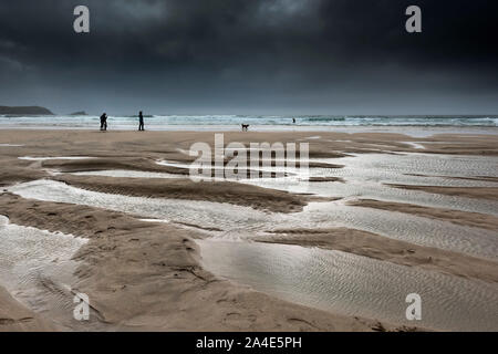 Ebbe als dunkle, dramatische Wolken auf den Fistral Beach in Newquay in Cornwall. Stockfoto