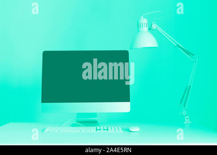 Designer Arbeitsbereich auf mint Farbe Hintergrund. Minimalistischer Home Office. Trendy Grün und Türkis. Tastatur, Maus, Bildschirm schwarz Stockfoto