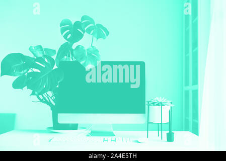 Designer Arbeitsbereich auf mint Farbe Hintergrund. Minimalistischer Home Office. Trendy Grün und Türkis. Tastatur, Maus, Bildschirm schwarz Stockfoto